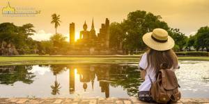Turista contemplando el atardecer en las ruinas de Sukhothai