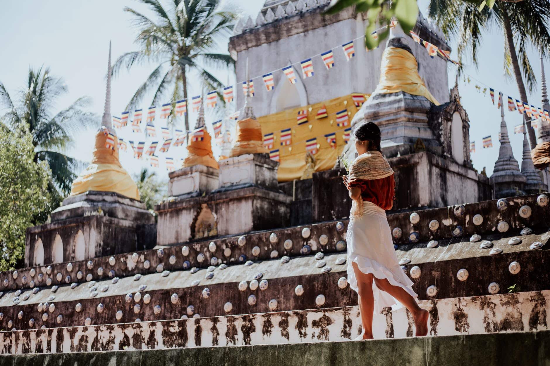 woman in white dress standing near gold temple